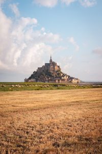 a large castle sitting on top of a hill in the middle of a field